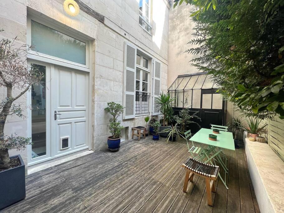 une terrasse avec une porte, une table et des plantes en pot dans l'établissement Le SeptièmeArt - Coeur de ville, à La Rochelle