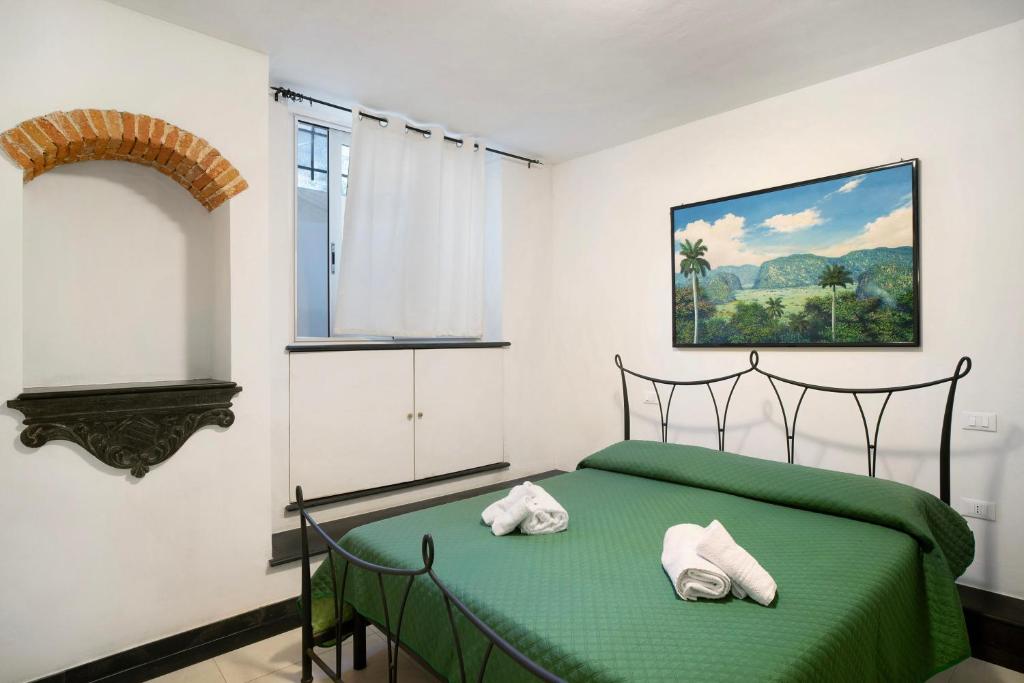 1 dormitorio con 1 cama verde y 2 toallas en Le terme, borgo dei pescatori en Cervo