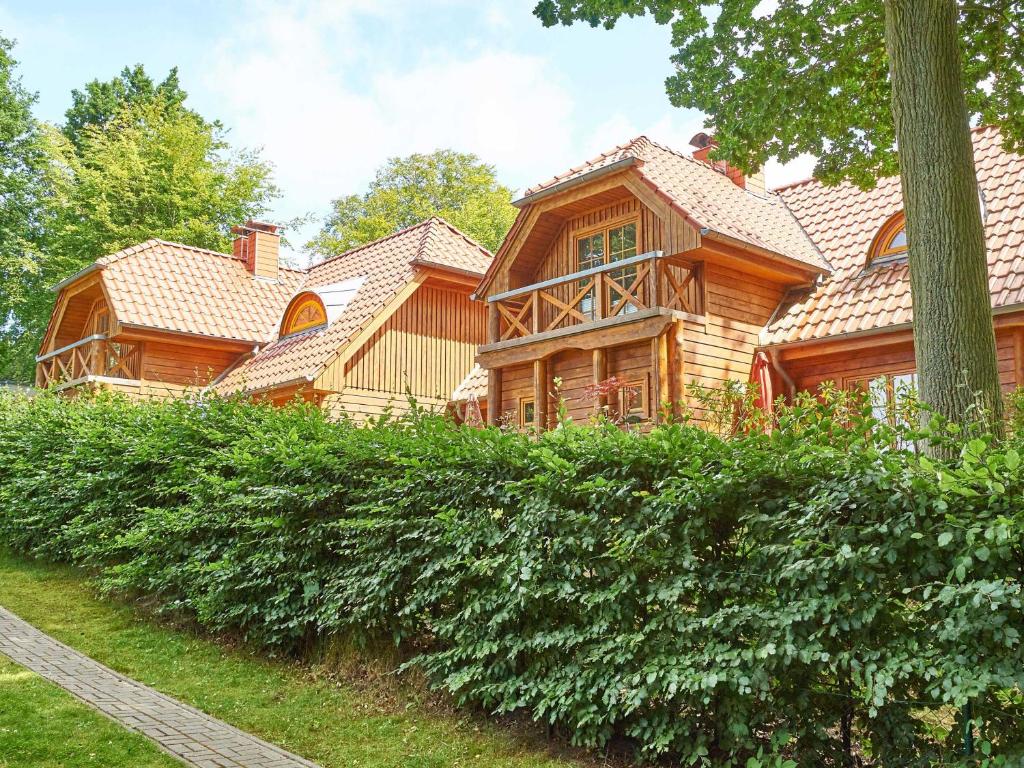 a large wooden house with a tree at Strandschlösschen Sellin - House Half 3 in Ostseebad Sellin