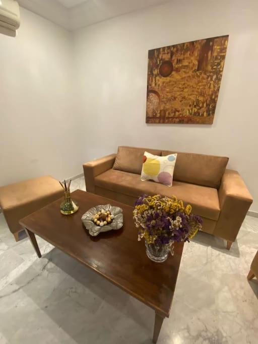 a living room with a couch and a table with flowers at Lac 2 apartement in Tunis