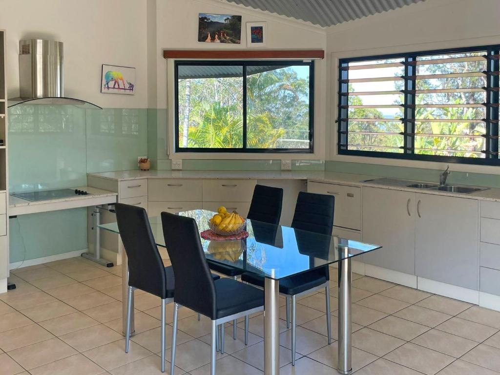 een keuken met een glazen tafel en zwarte stoelen bij Lush 2Bedroom Apartment in Yamba Hinterland in Ashby