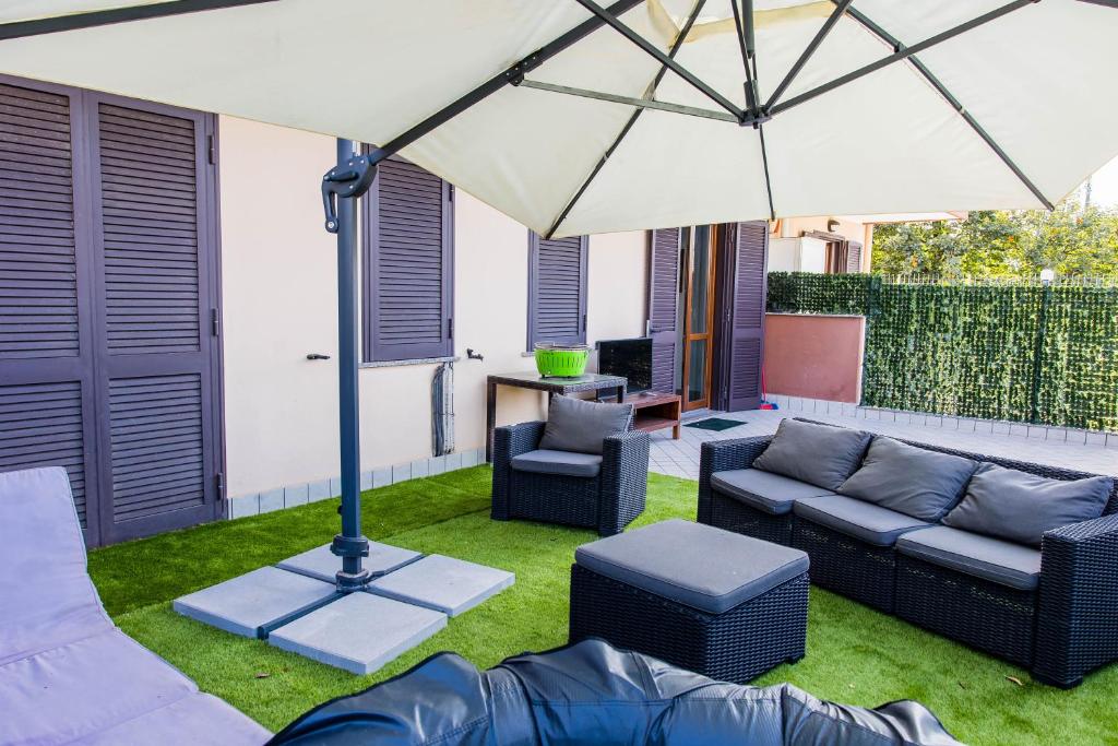 un patio con sofá y sombrilla en EMMEA8 APARTMENTS RELAX, en Angri