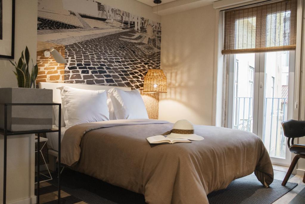 Un dormitorio con una cama con un libro. en room Select Liberdade en Lisboa