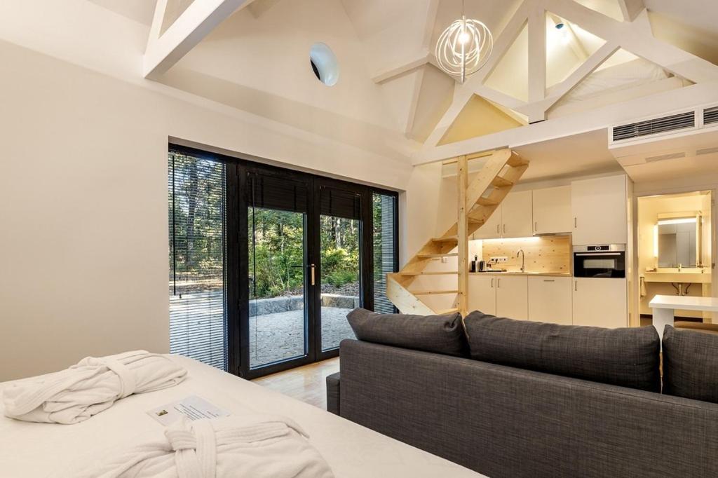 Una sala de estar con un sofá y una cocina. en Pedras Salgadas Spa & Nature Park, en Pedras Salgadas