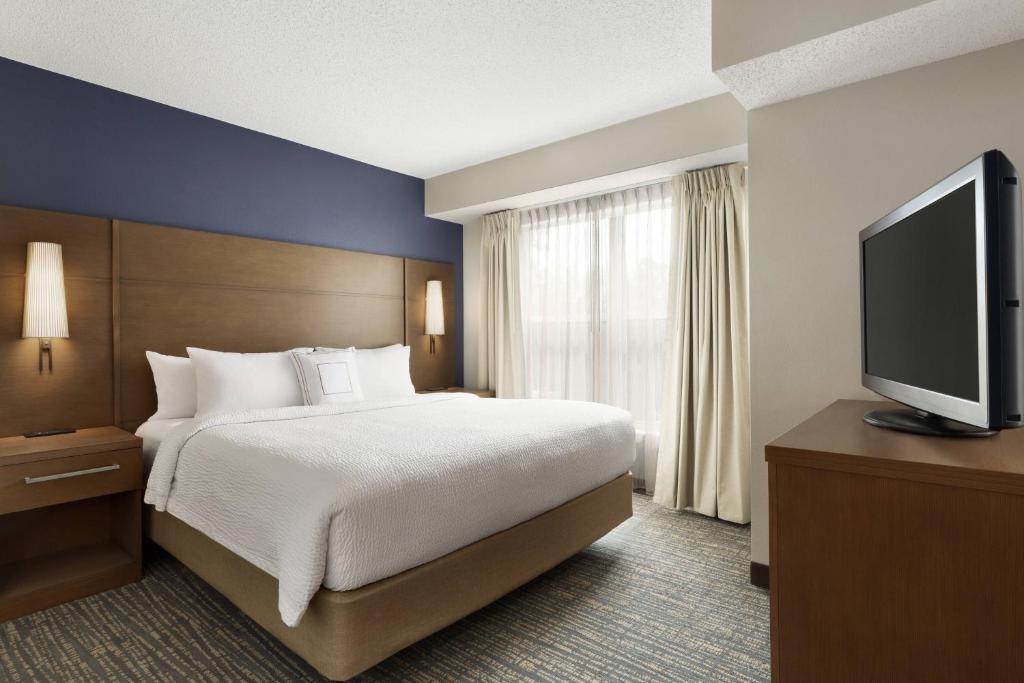 a hotel room with a bed and a flat screen tv at Residence Inn Houston The Woodlands/Market Street in The Woodlands