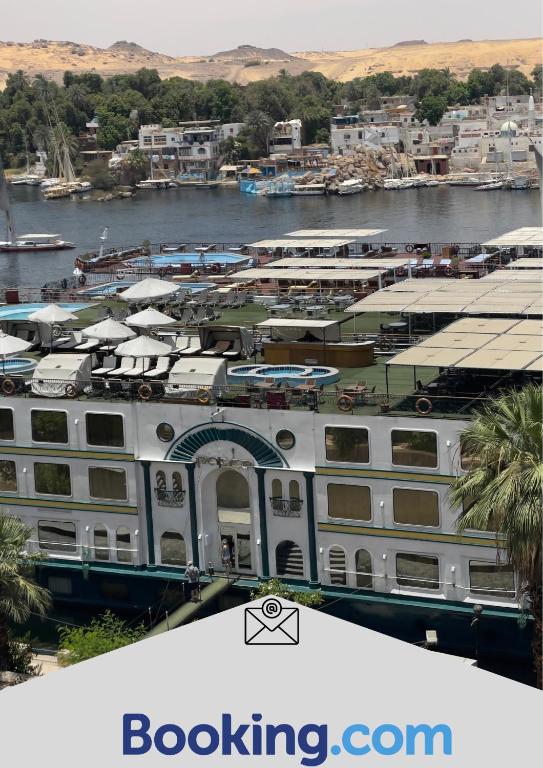 a large white building next to a body of water at Aswan sunrise in Aswan