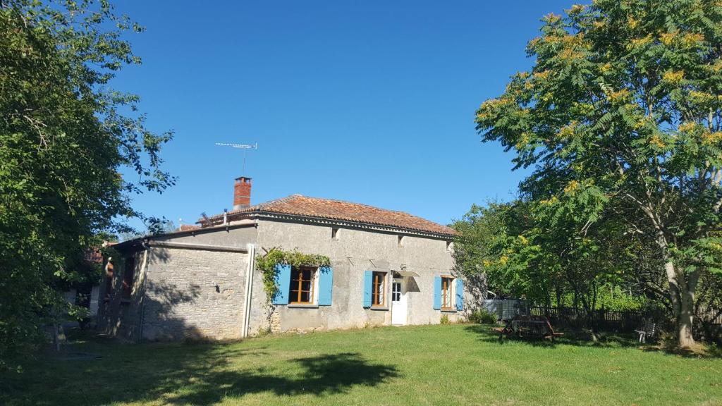 una vieja casa de piedra en un campo con árboles en Gîte Chez Chenon, en Saint-Sulpice-de-Ruffec