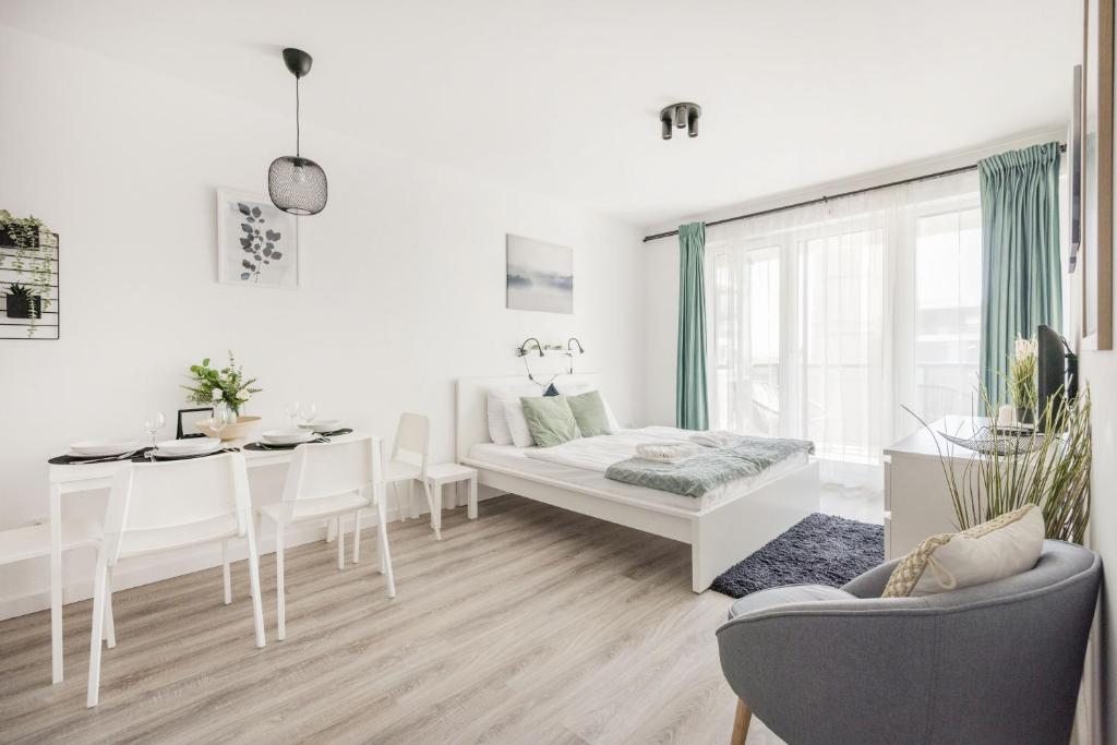 sala de estar blanca con mesa y sofá en Modern Riverfront Apartment with Free Parking en Budapest