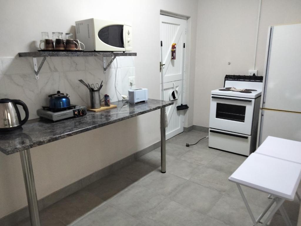 a kitchen with a counter with a stove and a refrigerator at Mila's place 35 Wellington Street in Cannonvale