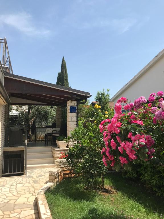 una casa con fiori rosa nel cortile di App Sorgo a Novigrad Istria