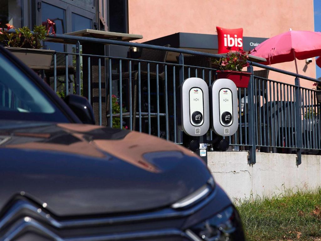 a pair of parking meters next to a fence at ibis Chalon Sur Saone Nord in Chalon-sur-Saône