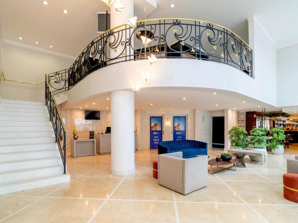 a large lobby with a spiral staircase in a house at Mercure Sao Paulo Ibirapuera Privilege in Sao Paulo
