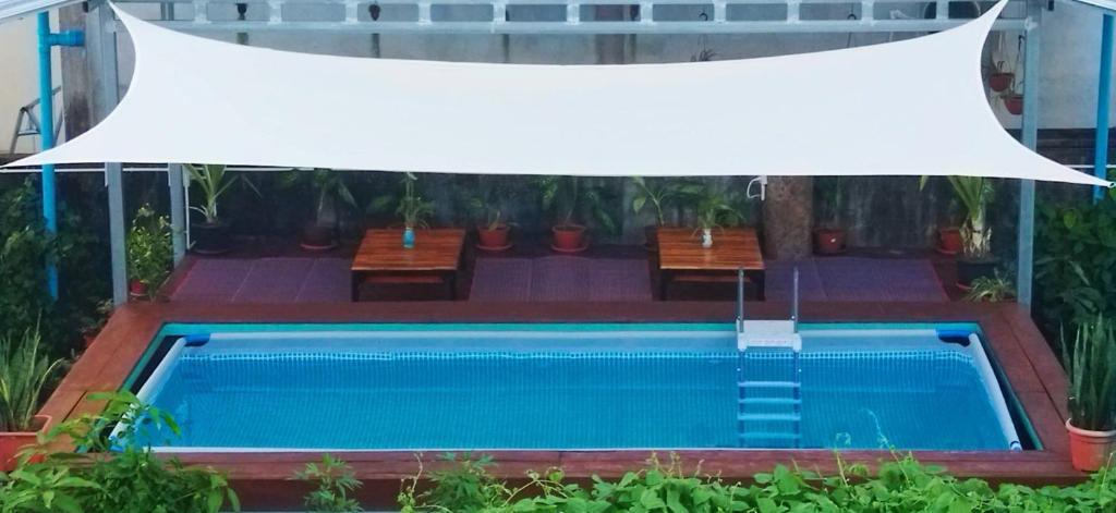 - une vue sur la piscine dotée d'un auvent blanc dans l'établissement Bamboo Hostel, à Thakhek