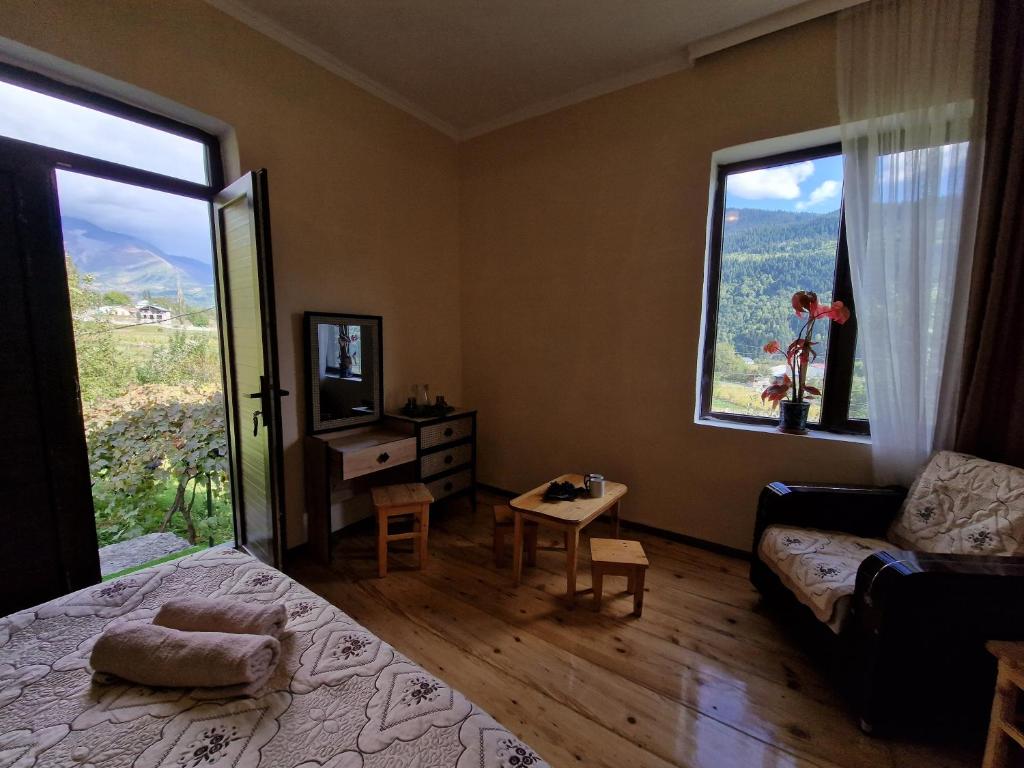 a bedroom with a bed and a large window at Bela's Guesthouse in Mestia