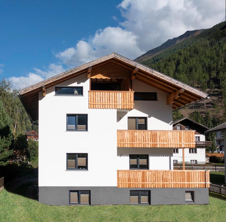 a white building with wooden balconies on it at Haus Paul in Kals am Großglockner