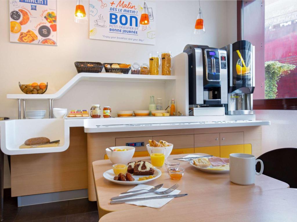 a kitchen with a table with food on it at ibis budget Perpignan Centre in Perpignan