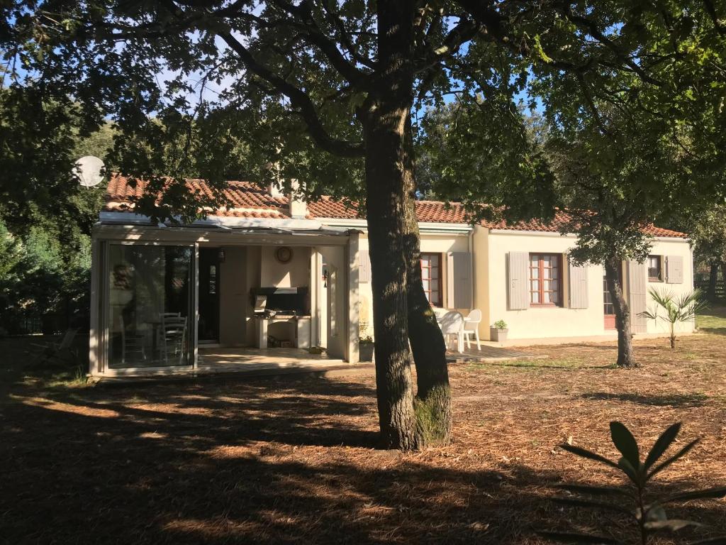 a white house with a tree in front of it at LA HULOTTE, VILLA ENTRE MER ET FORET -- draps et serviettes non fournis -- in Saint-Trojan-les-Bains