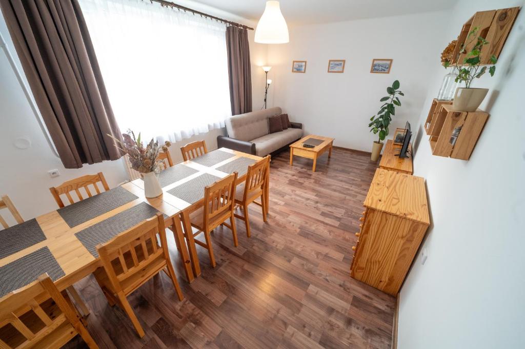 - un salon avec une table, des chaises et un canapé dans l'établissement Apartmány Olešnice, à Olešnice v Orlických horách
