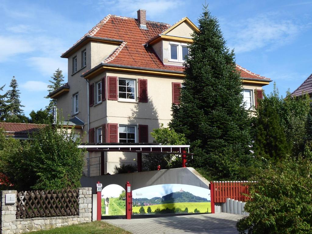 una casa grande con una valla roja delante de ella en Ferienwohnung zum Riesenlöffel, en Arnstadt