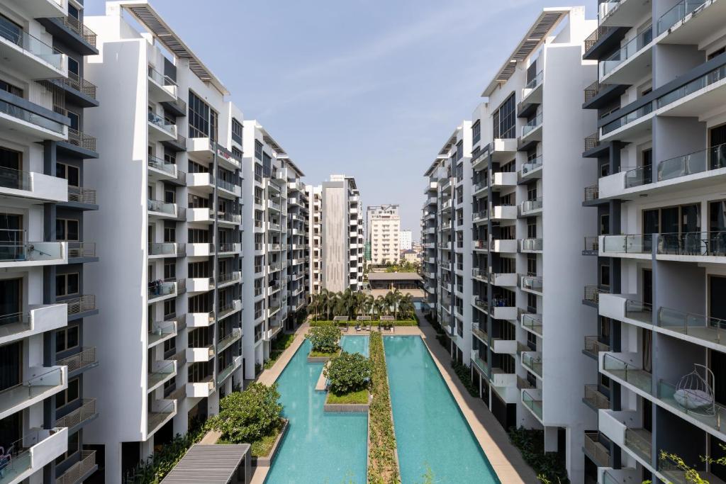 an apartment complex with a swimming pool between two buildings at Axis Residence by Caerus Management in Phnom Penh