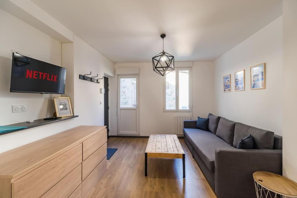 un salon avec un canapé et une télévision dans l'établissement L'escale en plein coeur de Lannion, à Lannion