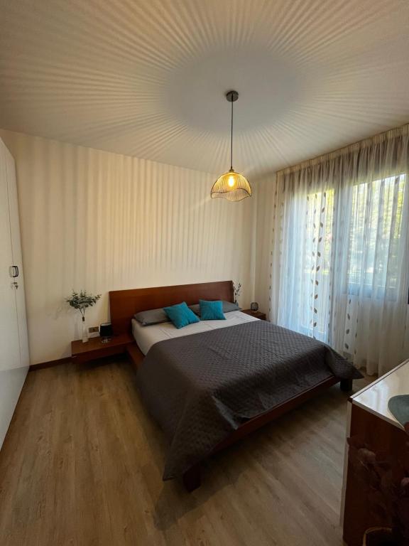 1 dormitorio con 1 cama grande con almohadas azules en Appartamento Ai Palasi, en Vittorio Veneto
