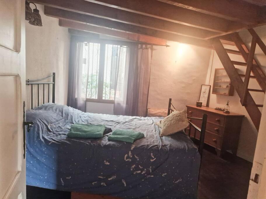 a bedroom with a bed and a dresser and a window at petite maison de village calme in Rodès