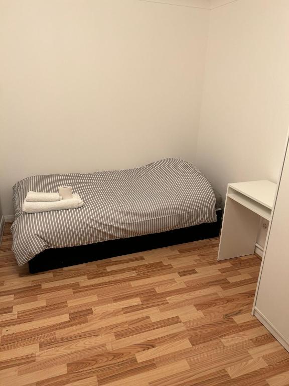 a bed in a room with a wooden floor at Kelvin Gardens in Croydon