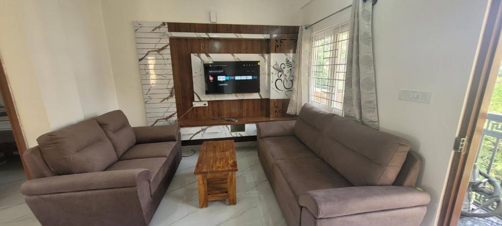 ein Wohnzimmer mit 2 Sofas und einem TV in der Unterkunft Castle HSR Sarjapur Road in Bangalore