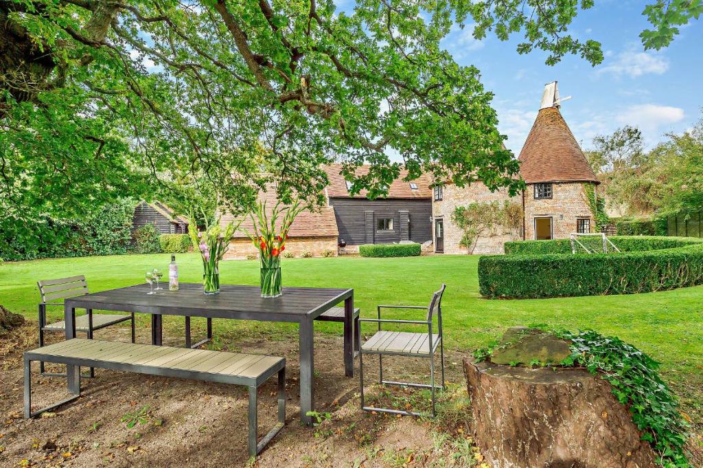 a table and a bench and a house at Court Lodge Oast in Heathfield