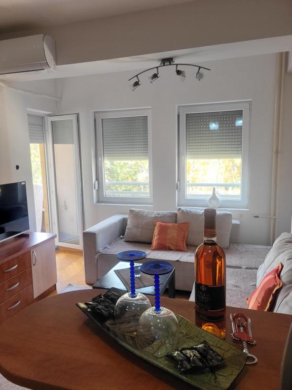 een woonkamer met een tafel met een fles wijn bij Nika's Apartment in Skopje