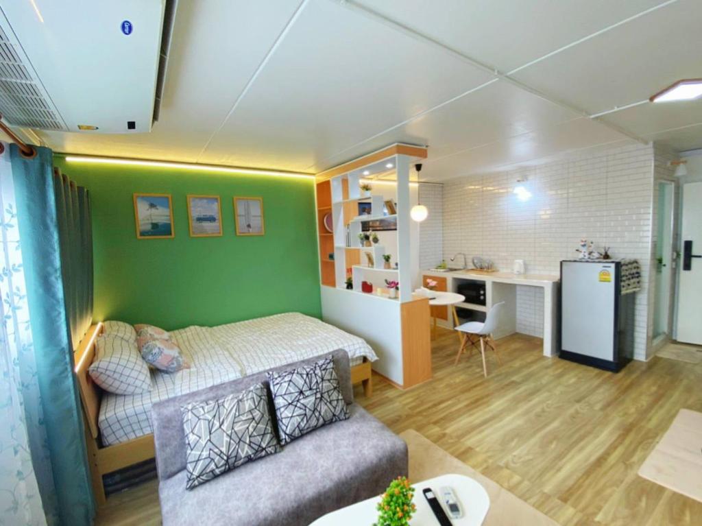 暖武里的住宿－PTJ Style Condotel คอนโดเมืองทอง P2，一间带一张床和一张书桌的卧室和一间厨房