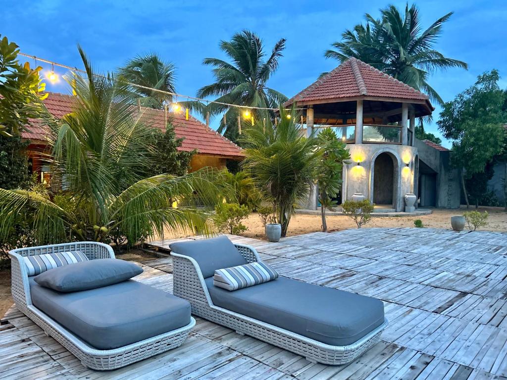a patio with two chairs and a gazebo at Arasi Resort in Kalpitiya