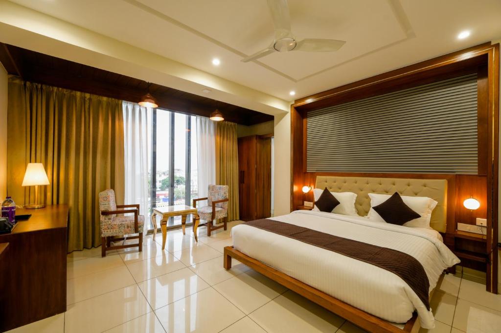 a bedroom with a large bed and a table and chairs at The Shivalik in Bhubaneshwar