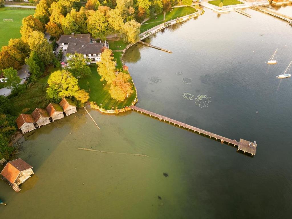 Strandhotel SüdSee Diessen am Ammersee في ديسن آم أميرسي: اطلالة جوية على جسر فوق سطح ماء