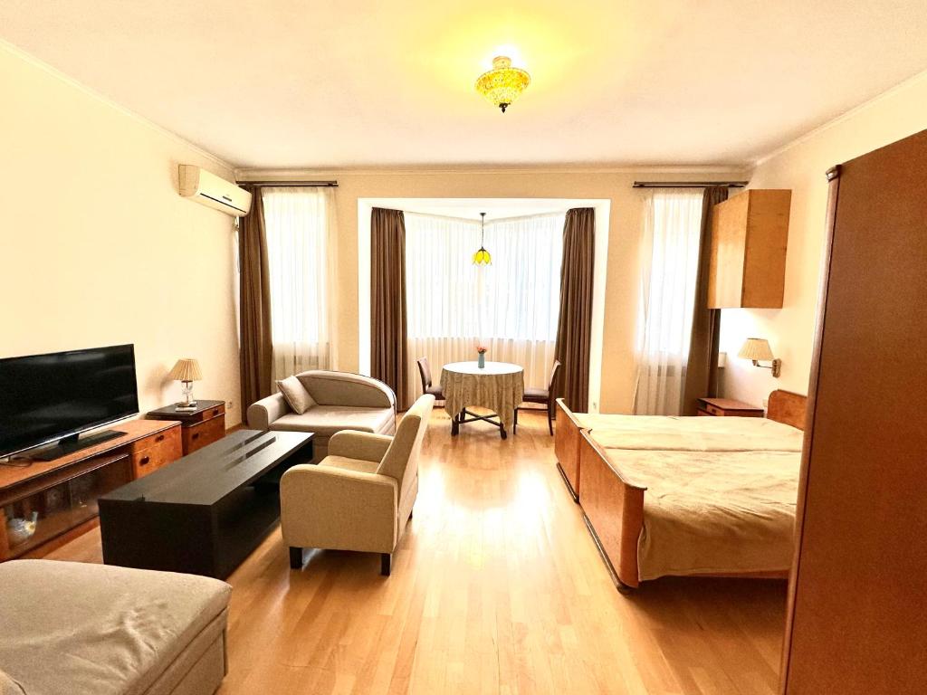 Una sala de estar con un sofá, una cama y una mesa. en Studio Flat in Center of Tbilisi, en Tiflis