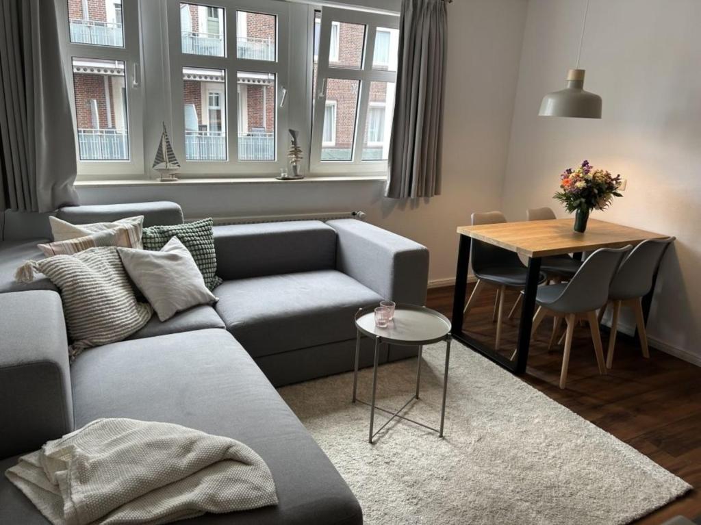 uma sala de estar com um sofá e uma mesa em Inselresidenz Strandburg - Ferienwohnung 106 em Juist