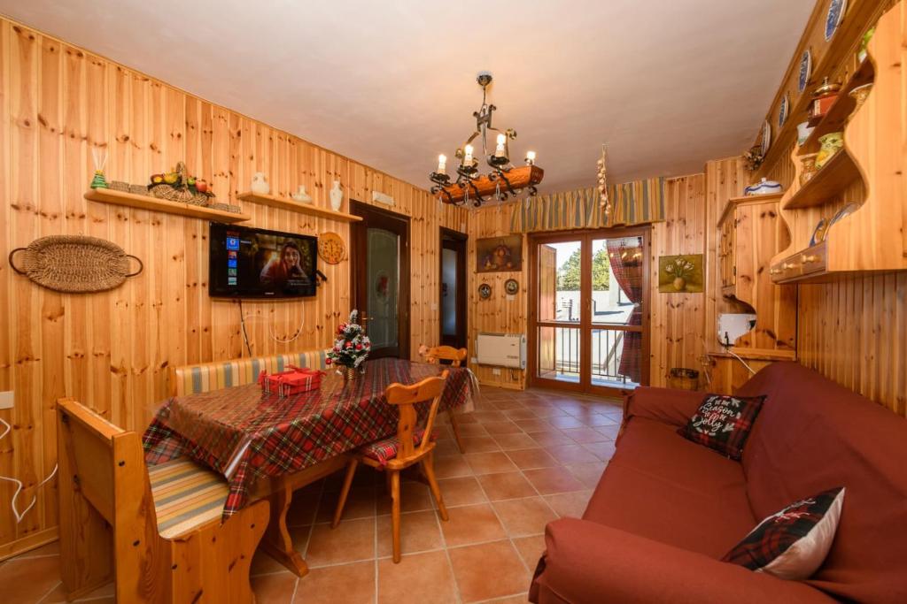 - un salon avec une table et un canapé dans l'établissement La Pineta di Giove - Casa Lory, à Campo di Giove