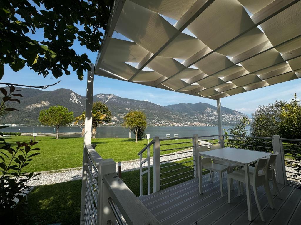 een veranda met een tafel en uitzicht op het water bij Belvedere Clusane Camping in Iseo