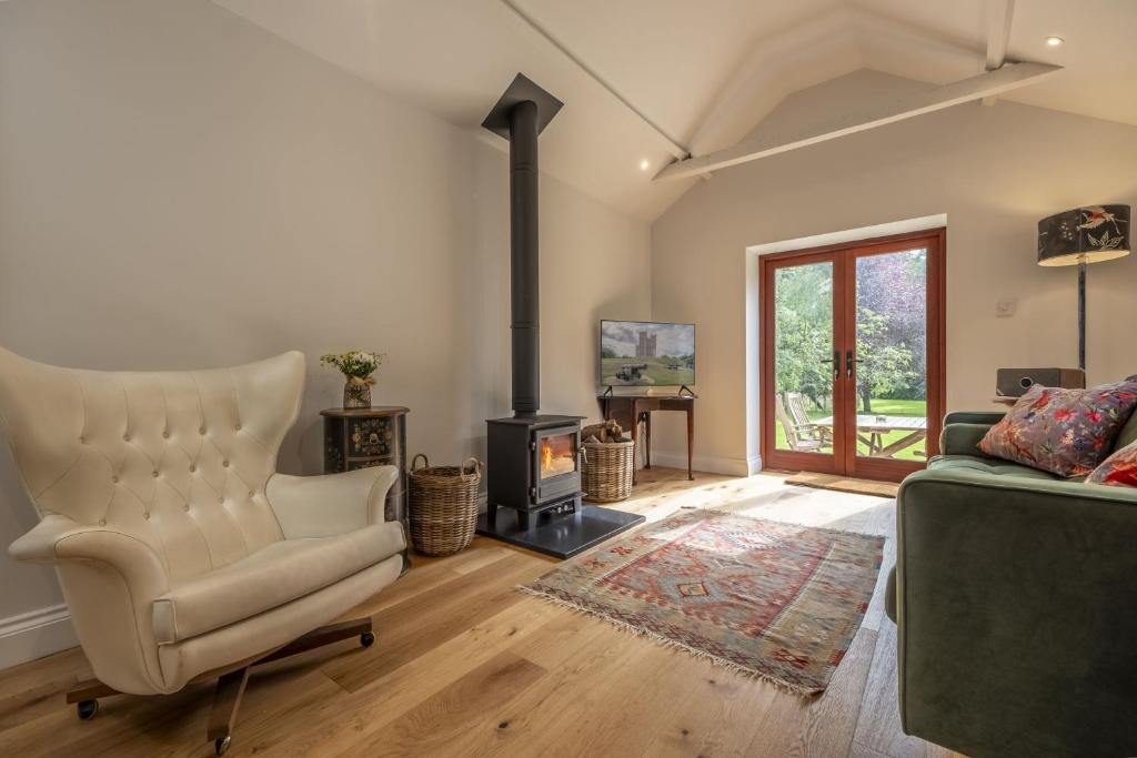 a living room with a couch and a wood stove at Weavers Mark Cottage in Diss