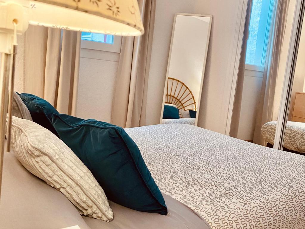 a bedroom with a bed with green pillows on it at Bright Apartment steps from Plaza de Toros and Wizink Center in Madrid