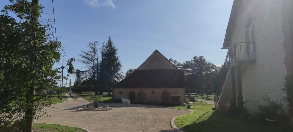 een kleine kerk met een zwart dak naast een gebouw bij Gîte Les Grandes Maisons cœur forêt d'Orléans et Espace bien-être jacuzzi hammam SPA in Lorris