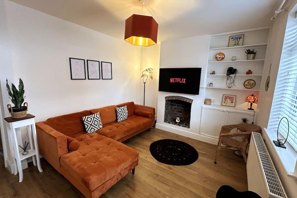 a living room with a couch and a fireplace at Two Bed Charming Cottage in Crewe