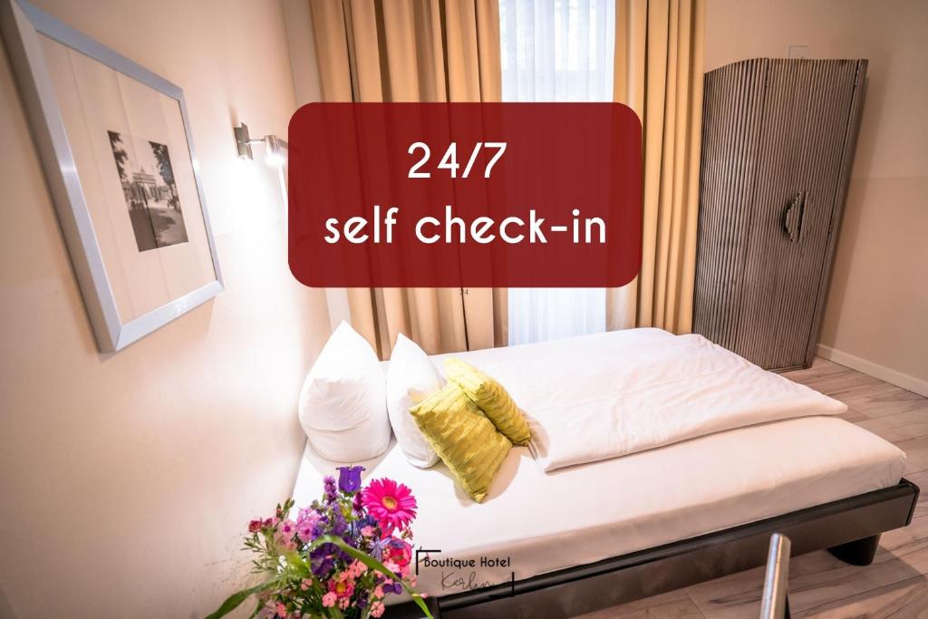 Boutique Hotel Kerlin في برلين: سرير في غرفة مع علامة تنص على تسجيل الوصول الذاتي
