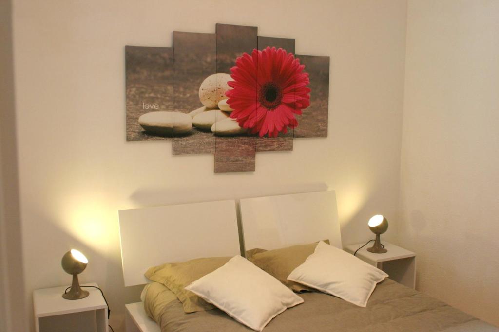 - une chambre avec un lit orné d'une fleur rouge sur le mur dans l'établissement Appartement Université-Capitole, à Toulouse