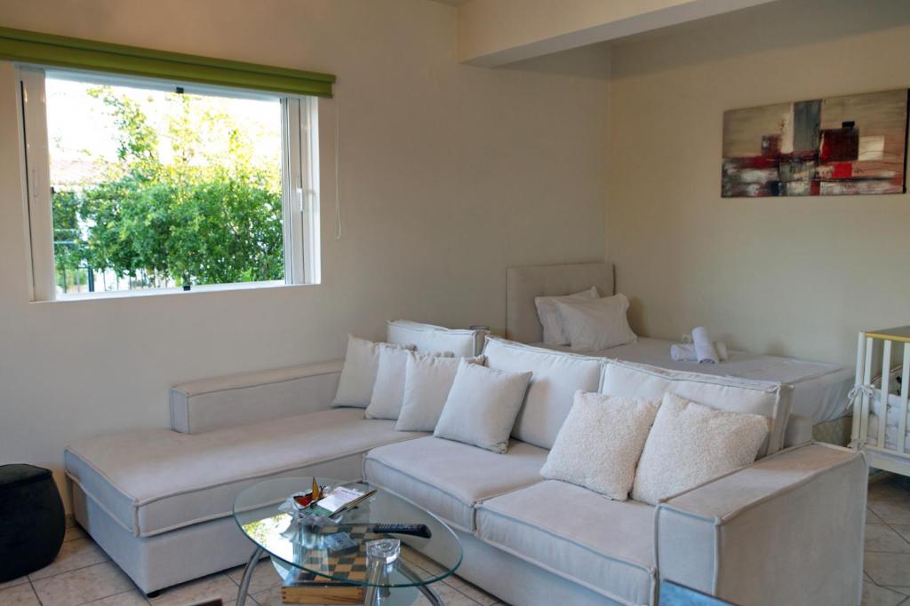 a living room with a white couch and a window at House with sea breeze-Anemelia in Nafplio