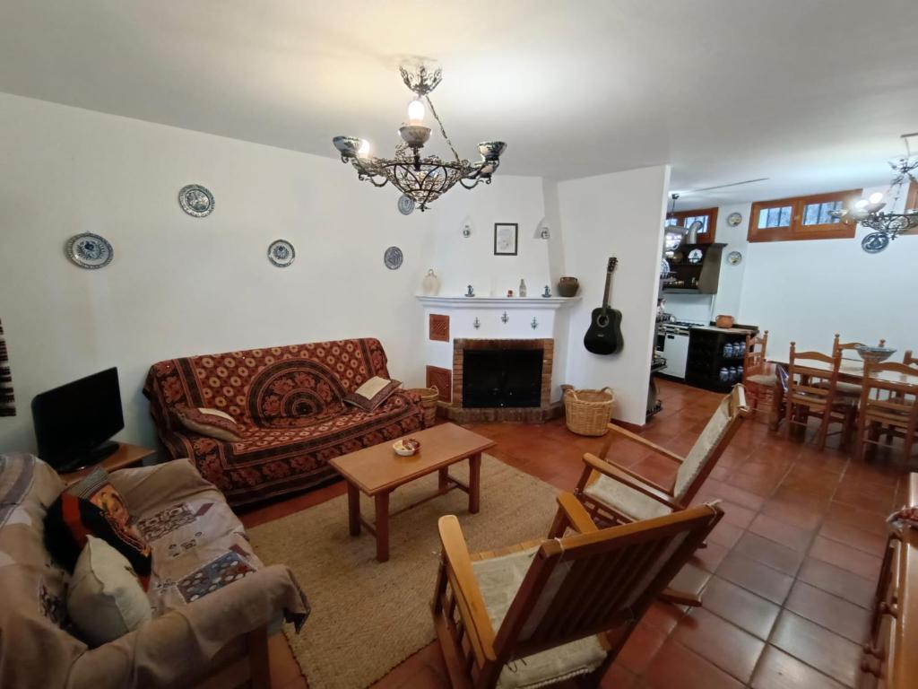 a living room with a couch and a fireplace at Casa Rural La Argentina in Bubión