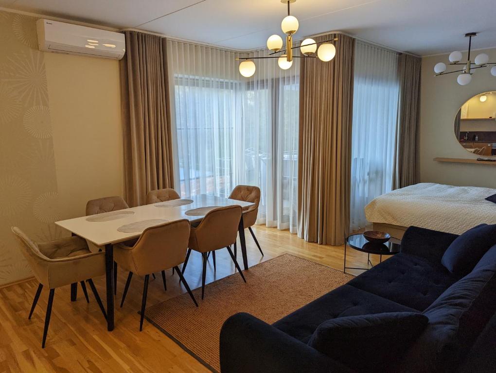 ein Wohnzimmer mit einem Bett, einem Tisch und Stühlen in der Unterkunft Studio Apartment with Sauna in Pärnu