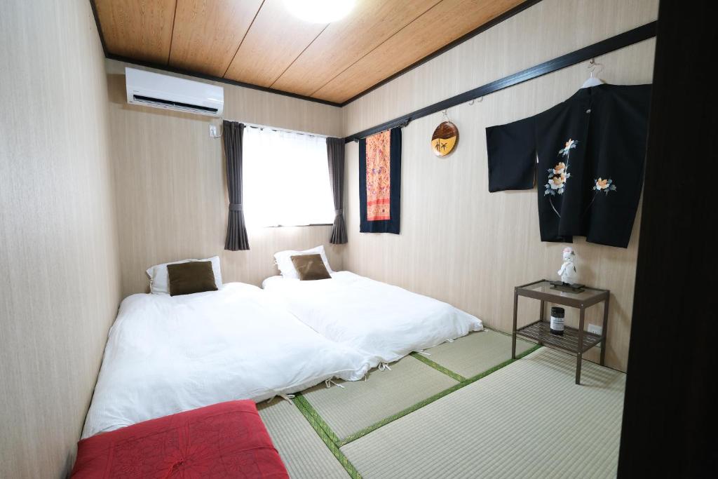Habitación pequeña con cama blanca y ventana en Housegreen, en Tokio