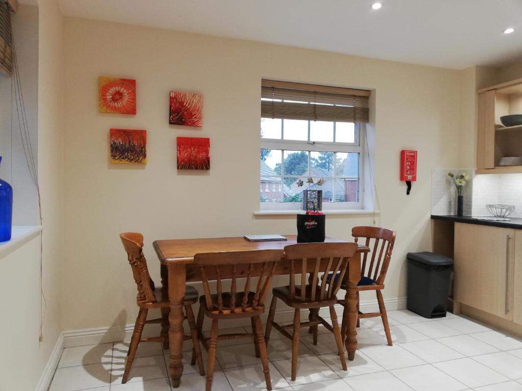 a kitchen with a wooden table and chairs at Brand New 2 bed in one of Newbury oldest buildings in Newbury